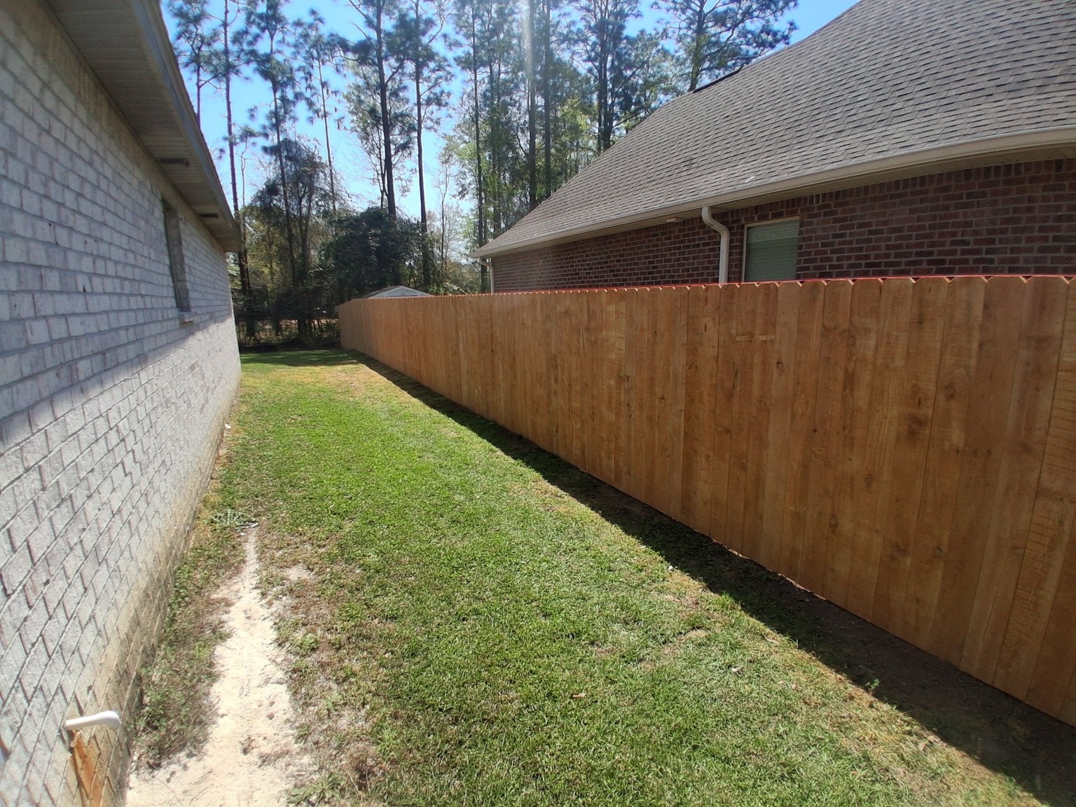 Godwin Fencing wood privacy fence beside a brick home